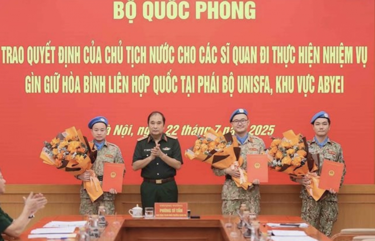 Senior Lieutenant General Phung Si Tan (second from left), Deputy Chief of the General Staff, presents decisions of the State President and the Minister of National Defence to three officers who are about to depart for duties at the UN peacekeeping mission in Abyei. (Photo: VNA)