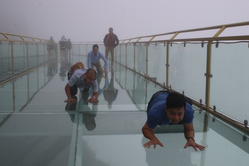 Tourists enjoy the experience of trying out various photo poses on Rong May glass bridge.