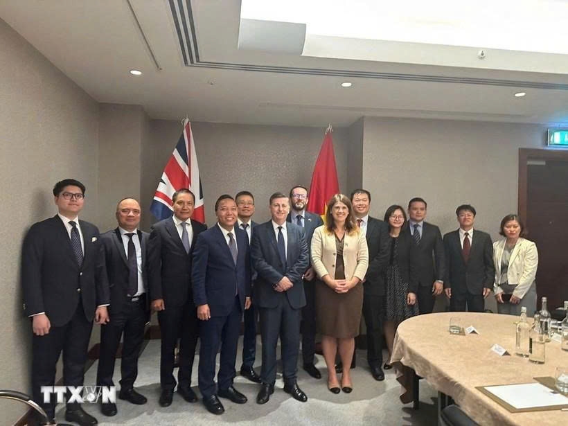 Deputy Minister Nguyen Hoang Long, Minister of State Douglas Alexander, and representatives from ministries and the embassies of both countries pose for a group photo at the 14th JETCO meeting. (Photo: VNA)