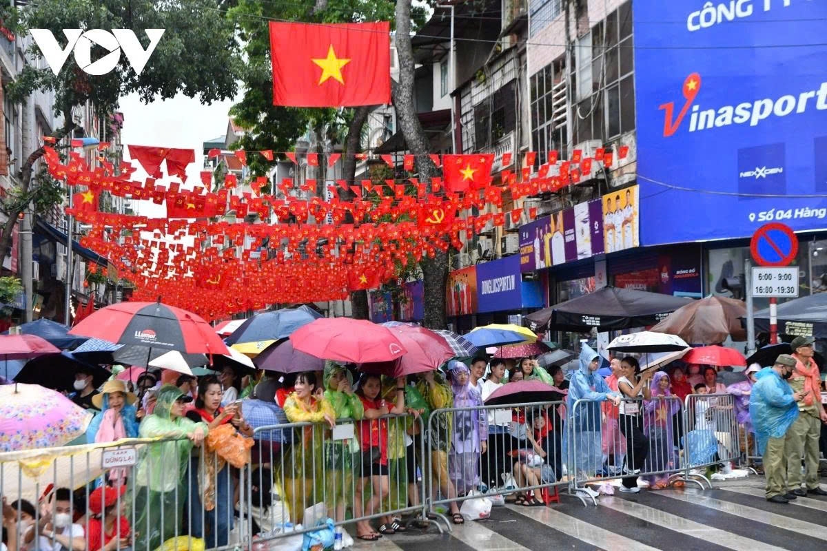 Despite alternating rain and sunshine, residents wait patiently and orderly until 8 p.m. to watch parade units pass by.