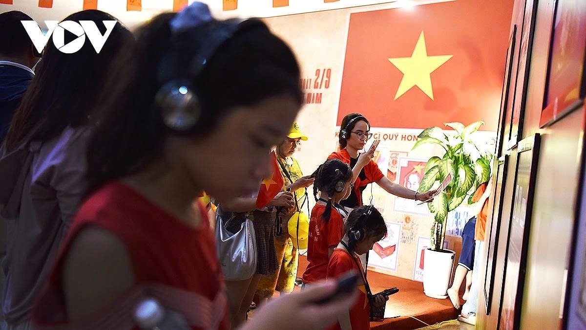 Residents, visitors, and many young people are revisiting historical and revolutionary stories through handheld digital devices at Hanoi Post Office.