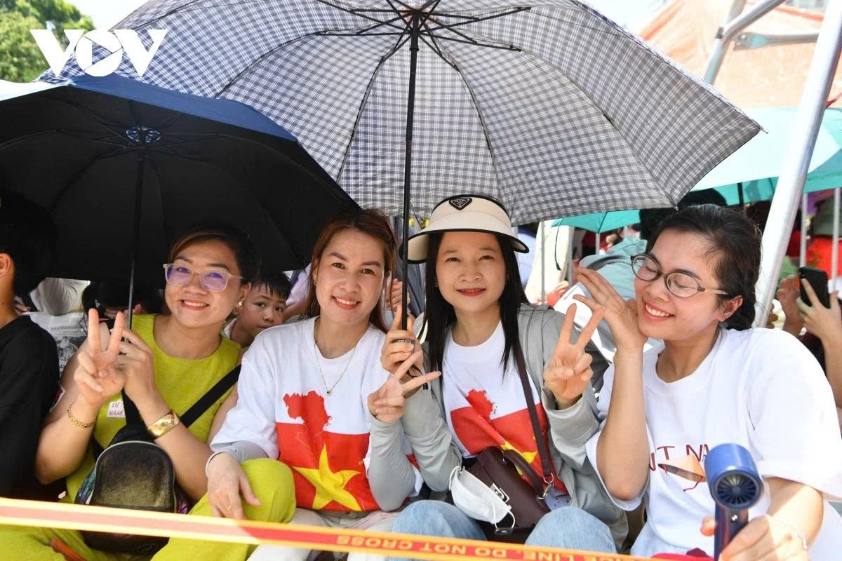 Nguyen Thi Thu Huyen (second from right) and her friends travel from Dan Phuong commune to Ba Dinh ward to secure a 'prime spot.' They bring with them essential supplies and find a suitable place along Hung Vuong Street, ready to wait for several hours until the rehearsal begins.