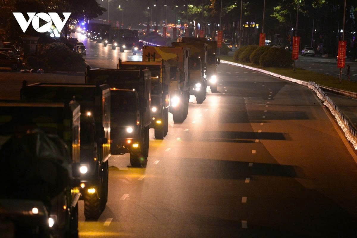 Vehicles move in waves, each only a few minutes apart. Many are covered with tarpaulins and transported on specialized carriers for safety.