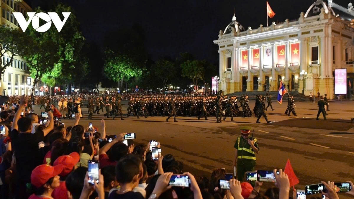 Lao troops march past the Opera House in Hanoi