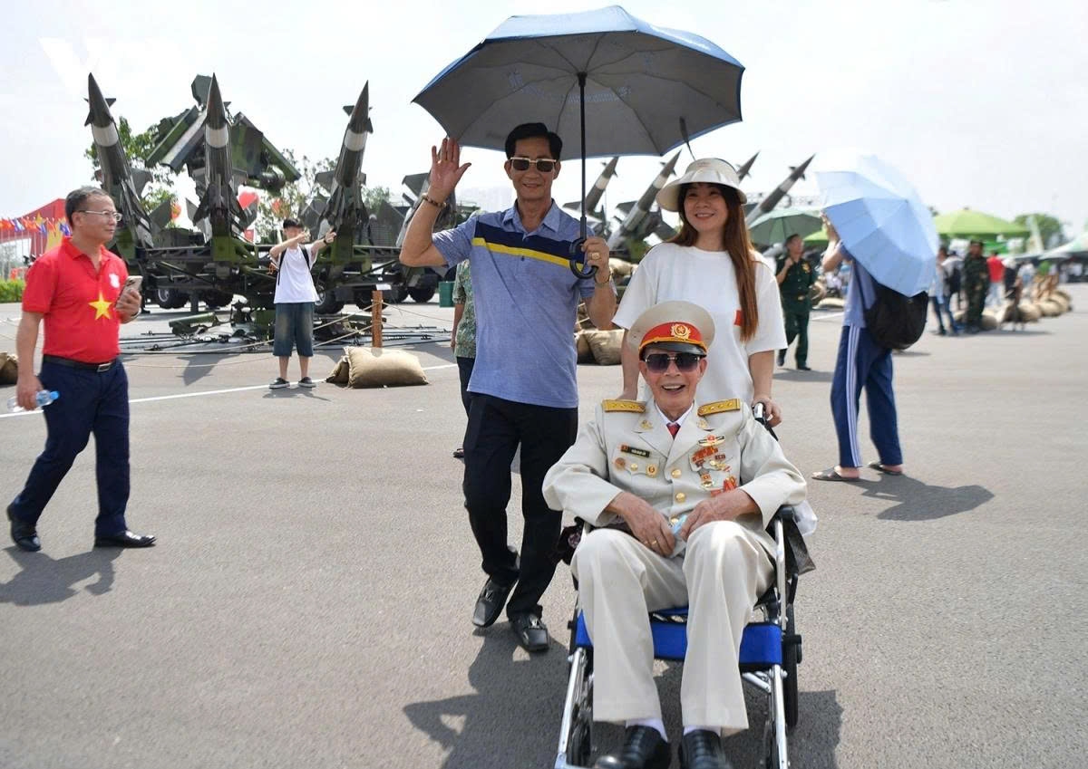 A veteran smiles alongside family members while visiting the outdoor exhibition area “The Sword and the Shield” of the Ministry of National Defence.