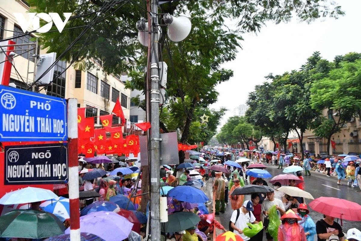 Residents throng along both sides of Nguyen Thai Hoc street despite heavy rain on the afternoon of August 24.