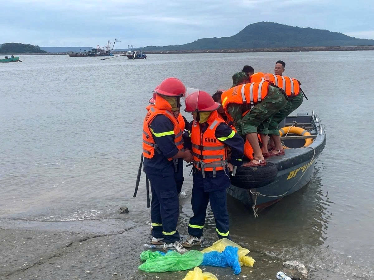 Rescue workers bring ashore the people from the raft that capsizes due to a thunderstorm in the waters