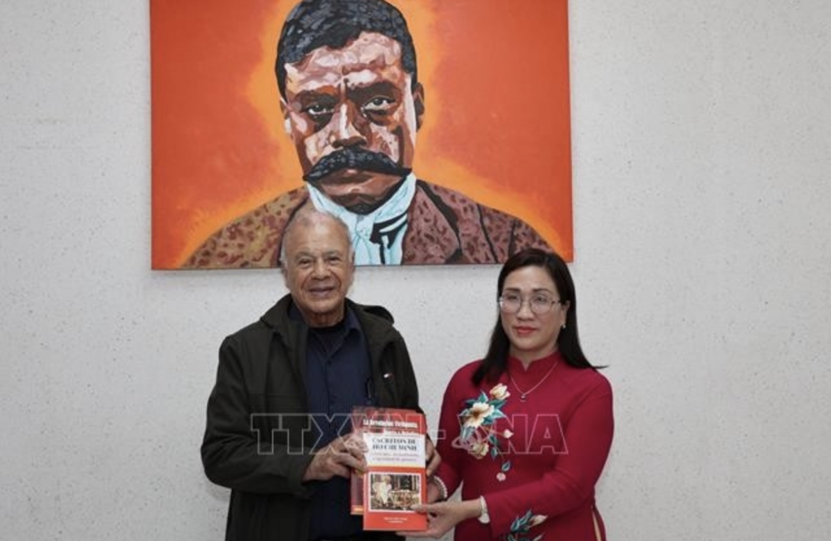 Alberto Anaya Gutiérrez, General Secretary of the Labour Party (PT) of Mexico, presents Dinh Thi Mai, Deputy Head of the Party Central Committee’s Commission for Information, Education and Mass Mobilisation, with Spanish-language publications on Vietnam printed and distributed by the PT in Latin America. (Photo: VNA)