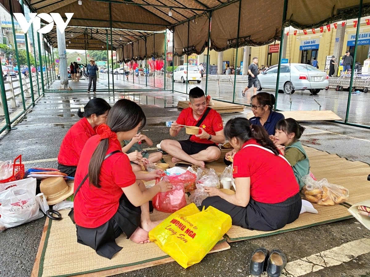 A family traveling from Tuyen Quang to Hanoi gather inside public tents set up by authorities to wait for the event