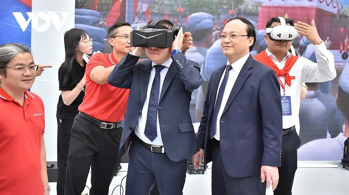 Le Quoc Minh, who is a member of the Party Central Committee, Vice Chairman of the Party Central Committee's Commission for Information, Education and Mass Mobilisation, and Editor-in-Chief of the Nhan dan (People) daily, enjoys virtual reality experience at VOV booth.