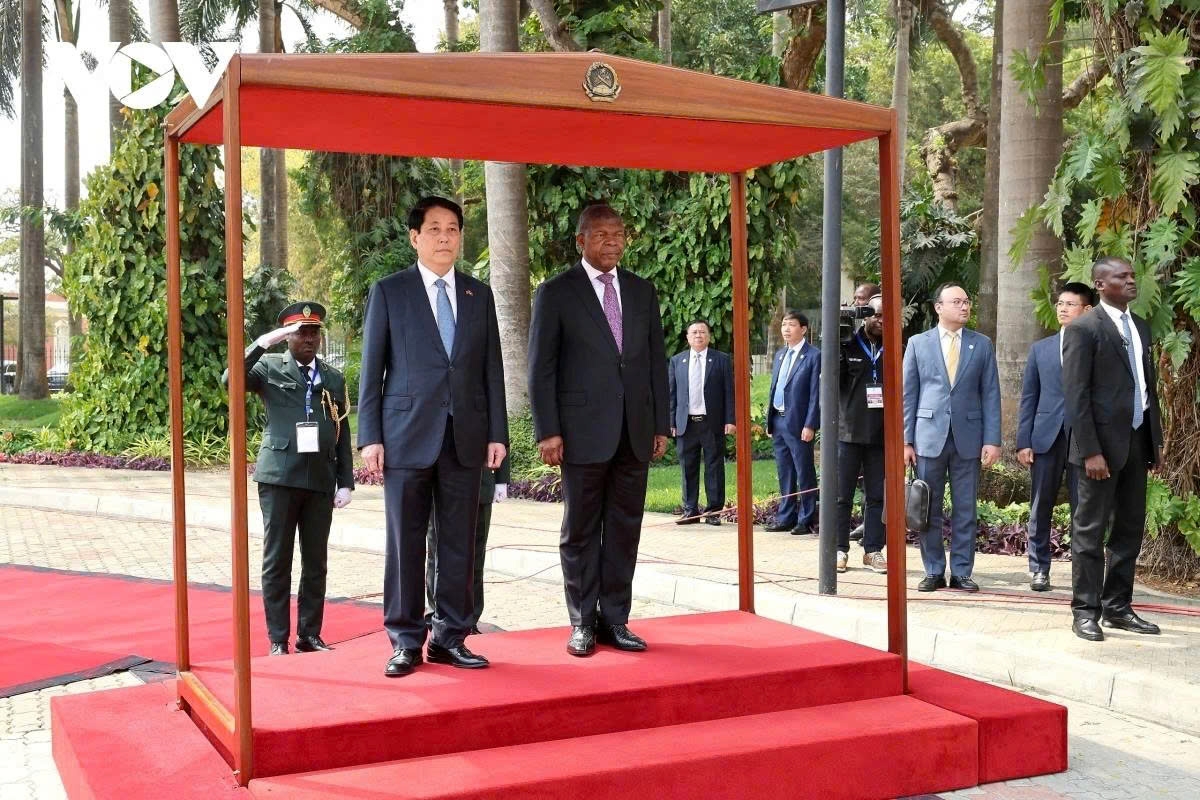 Angolan President Joao Manuel Goncalves Lourenco (R) and Vietnamese President Luong Cuong on the honour podium render the flag salute