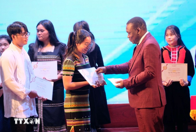 Esperan Padonou, director of the Vallet Scholarship Fund, presents the scholarships to the outstanding students (Photo: VNA)