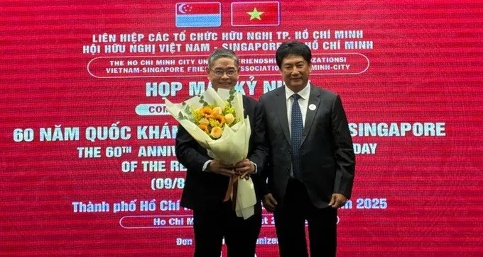 Chairman of the Vietnam–Singapore Friendship Association of Ho Chi Minh City Lam Dung Tien presents flowers to Singapore Consul General in HCM City Pang Te Cheng at the gathering.
(Photo: sggp.org.vn)