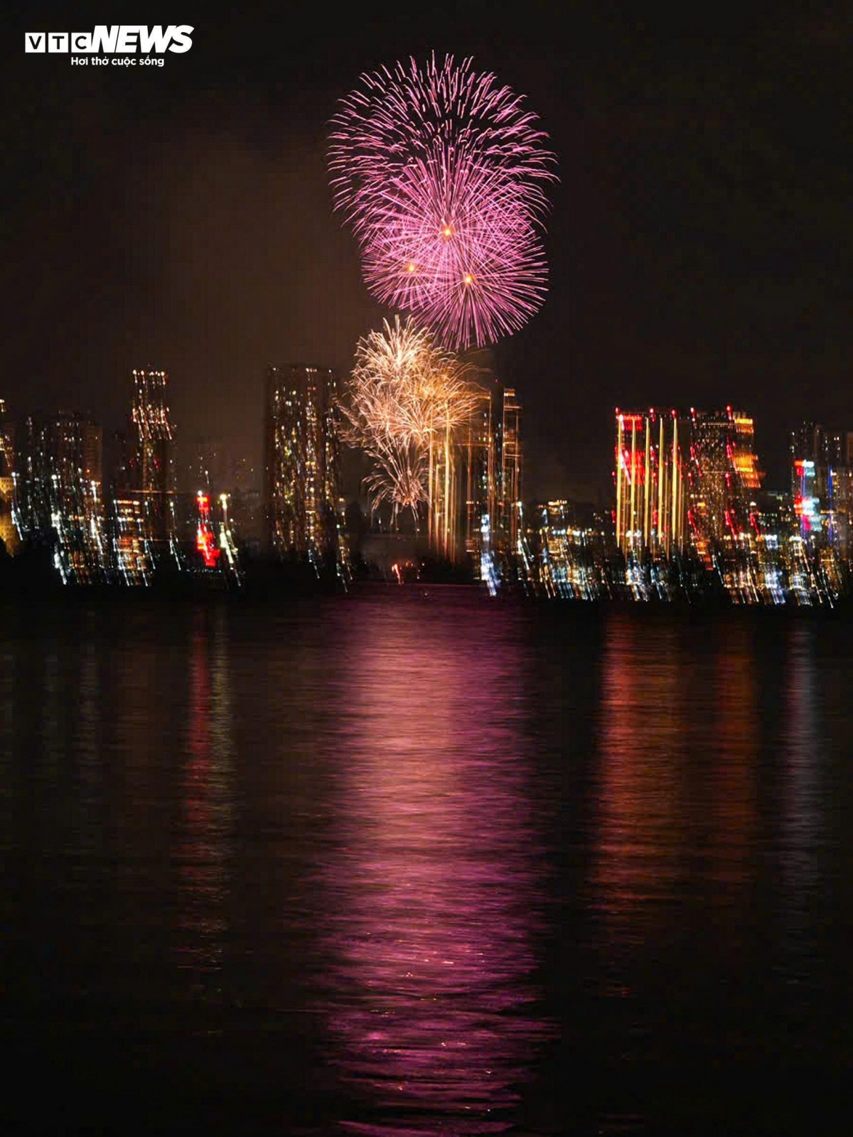 Red, yellow, blue, and purple lights dazzle in succession, reflecting on the lake’s surface and creating a magical, sparkling scene.