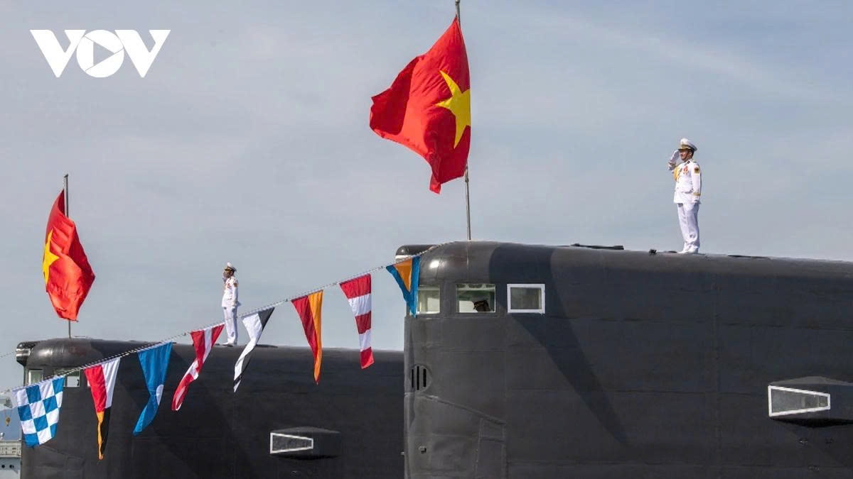 Sailors hold a flag-raising ceremony aboard a Kilo-class submarine
