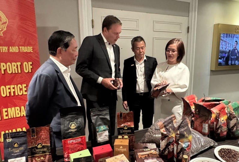 Trade Counsellor Tran Thu Quynh (first, right) introduces high-quality coffee products of Vietnam to Chairman of the Coffee Association of Canada Robert Carter (second from the left). (Photo: VNA)