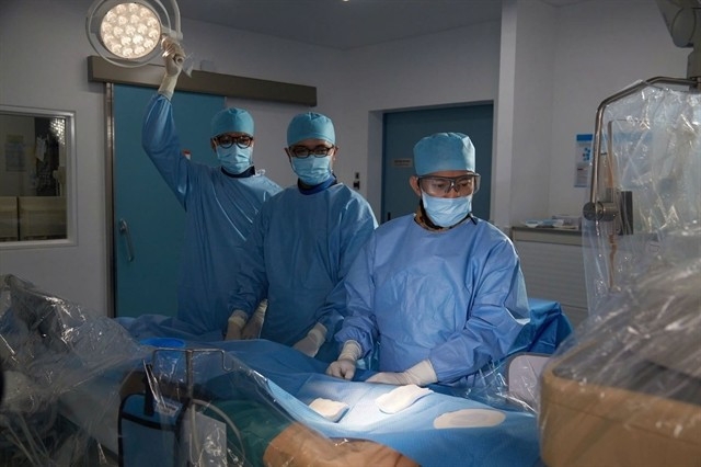 Dr Ho Minh Tuan performs the cardiac catheterisation procedure on the patient. (Photo courtesy of the hospital)