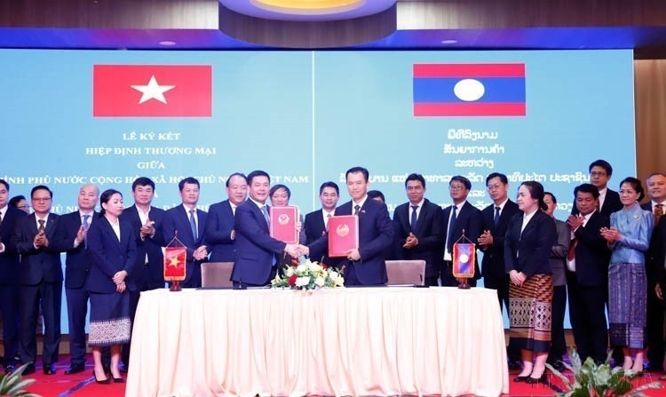 Minister of Industry and Trade Nguyen Hong Dien and his Lao counterpart Malaithong Kommasith sign the Vietnam - Laos Trade Agreement on April 8, 2024. (Photo: VNA)