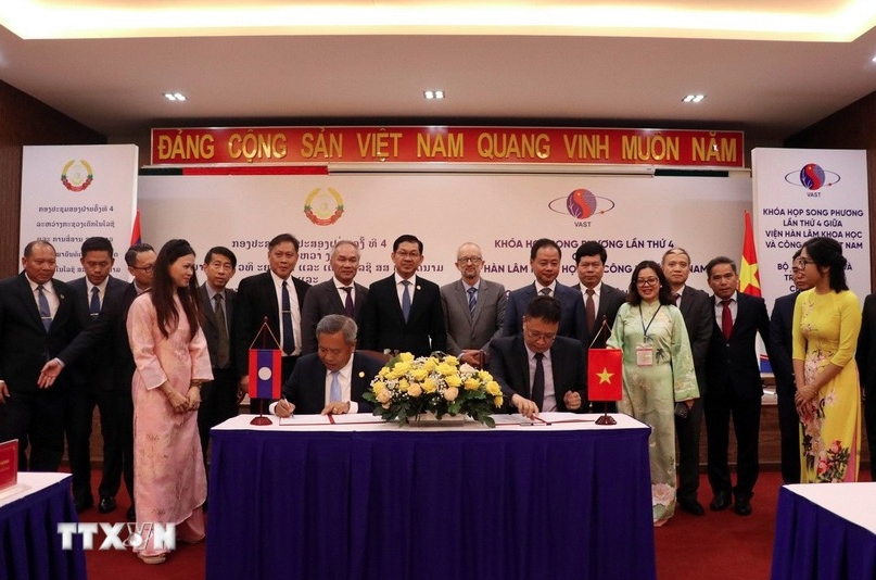 The signing of the minutes of the meeting between the Vietnam Academy of Science and Technology and the Lao Ministry of Technology and Communications. (Photo: VNA)