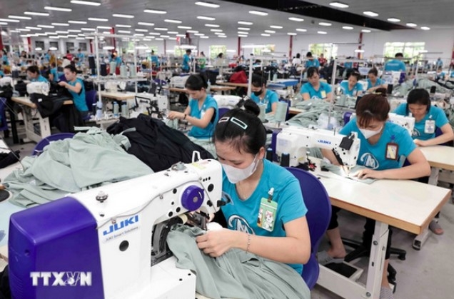 Workers produce garments for export. (Photo: VNA)
