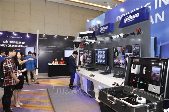 Visitors explore a technology exhibition on cybersecurity and safety equipment.