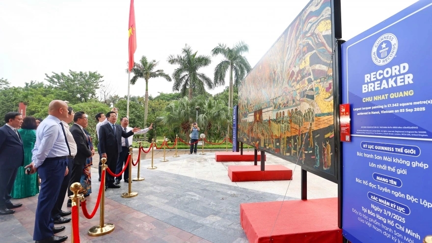 Deputy Prime Minister Mai Van Chinh and other delegates admire the lacquer painting