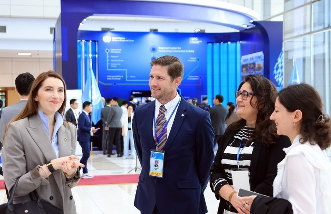 Delegates talk with each other on the sidelines of the event on October 26. (Photo: VNA)
