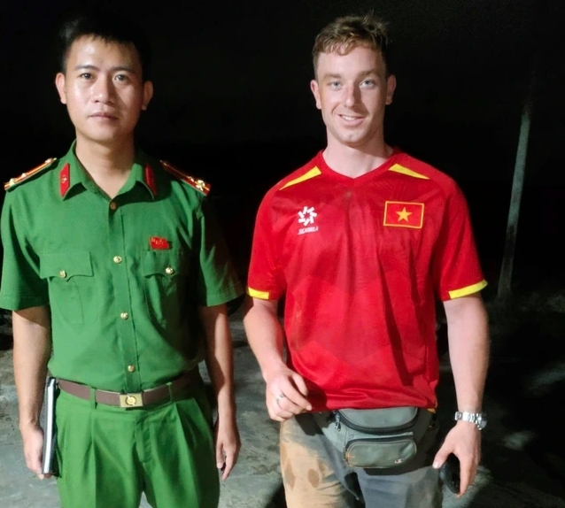 One of the two Dutch tourists poses for a photo with a local police officer (Photo: thanhnien.vn)
