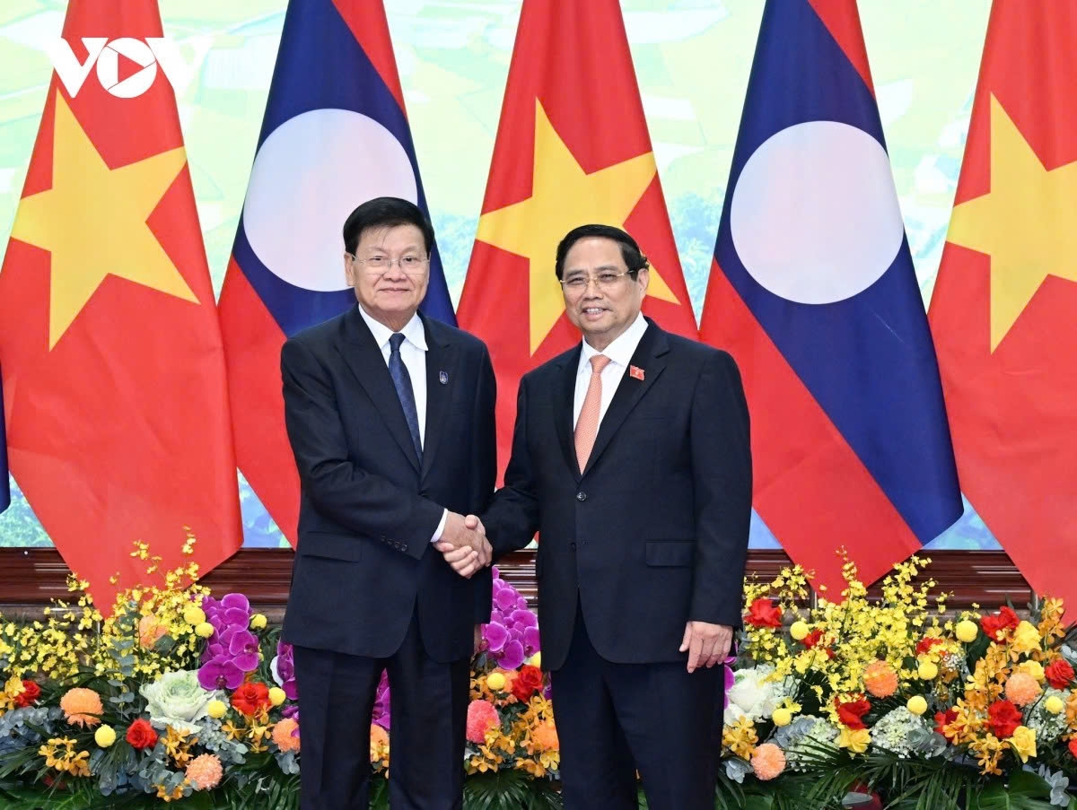 Vietnamese Prime Minister Pham Minh Chinh (R) receives Lao General Secretary and President Thongloun Sisoulith in Hanoi on October 24 for the signing of the Hanoi Convention 
