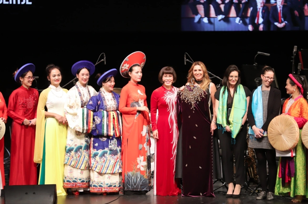 Dr. Phan Bich Thien (middle) presents a handcrafted Vietnamese Ao Dai to artist Miklósa Erika