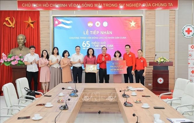 Deputy General Director of the Vietnam News Aagency Nguyen Thi Su (fifth, from right) presents donations to the Cuban people to the Vietnam Red Cross Society.