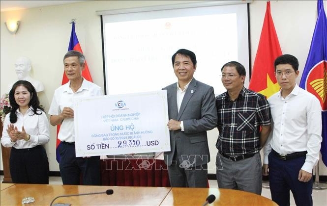 A representative of the Vietnam–Cambodia Business Association (VCBA) presents its donated fund to the leaders of the Vietnamese Ambassador to Cambodia Nguyen Minh Vu (2nd from left).