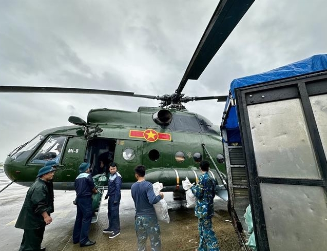 Relief supplies are loaded onto a helicopter for delivery to residents who remain isolated by floodwaters in the south-central provinces. (Photo: VNA)