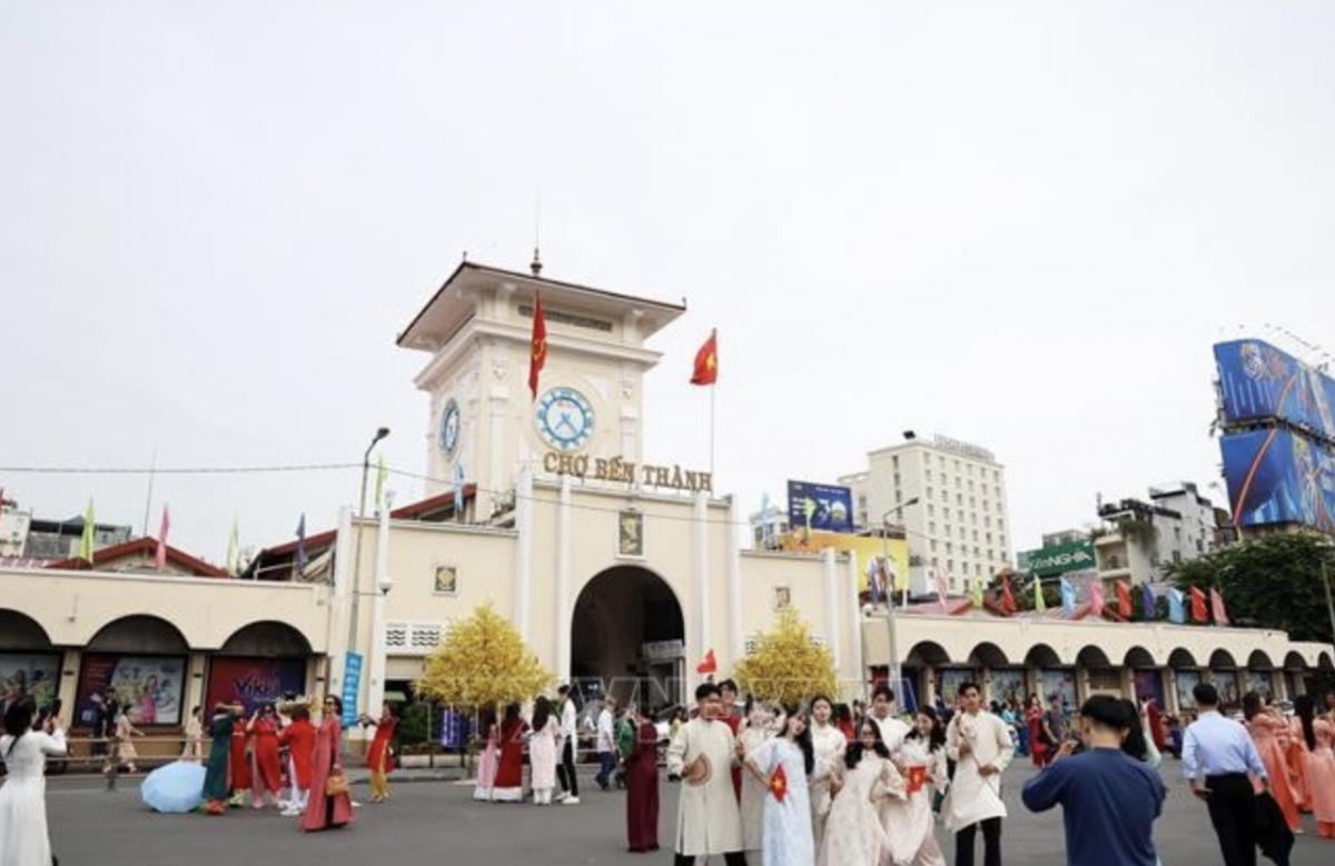 Tourists pose for photos in front of Ben Thanh Market, Ho Chi Minh City. (Photo: VNA)