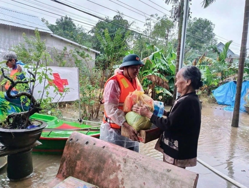 A representative of the Vietnam Red Cross Society delivers relief to a flood-hit resident in Hue city. (Photo: VNA)