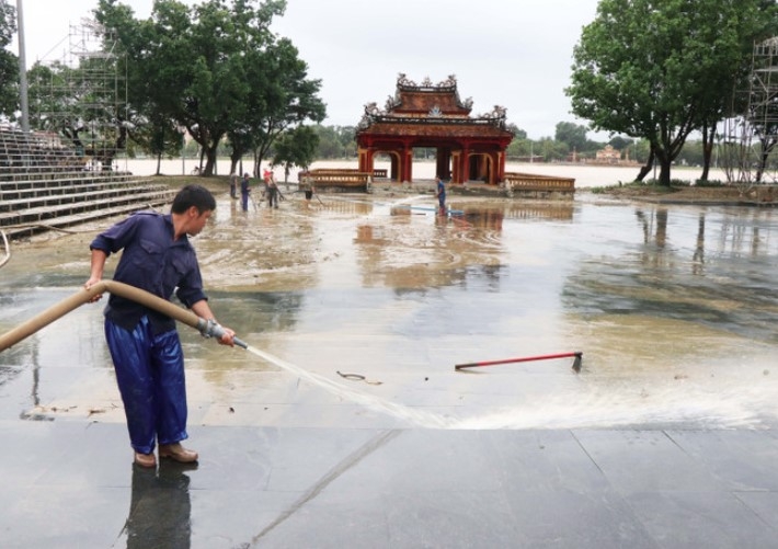 Workers wash mud from the Nghinh Luong Dinh relic site in Hue city (Photo: VNA)