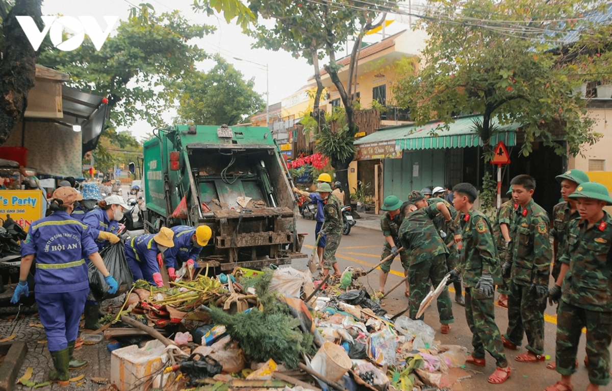Soldiers and sanitation workers clear debris