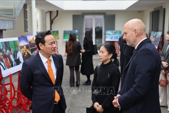 Ambassador Mai Phan Dung, Head of the Permanent Mission of Vietnam to Geneva exchanges views with international friends at the photo exhibition (Photo: VNA )