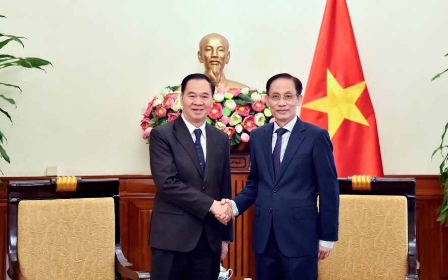 Minister of Foreign Affairs Le Hoai Trung (R) and Lao Minister of Education and Sports Thongsalith Mangnomek at their meeting in Hanoi on December 16. (Photo: Vietnamese Ministry of Foreign Affairs)