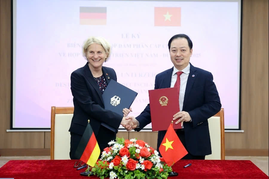 Hoang Hai, Deputy Director of the Department of Debt Management and External Economic Relations under the Ministry of Finance, and Gisela Hammerschmidt, Deputy Director General at the Federal Ministry for Economic Cooperation and Development, exchange the minutes of the intergovernmental negotiations in Hanoi late November 2025