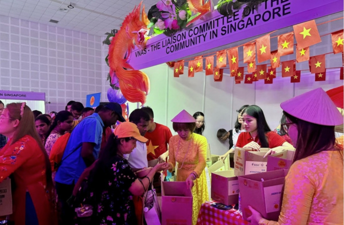 Large numbers of migrant workers queue to receive gifts at the Vietnamese community’s booth (Photo: VNA)