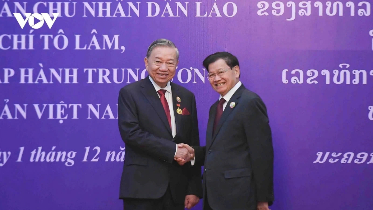 The Party General Secretary and President of Laos, Thongloun Sisoulith (R), presents the National Gold Order, the highest honour of Laos, to visiting Vietnamese Party General Secretary To Lam in Vientiane on December 1