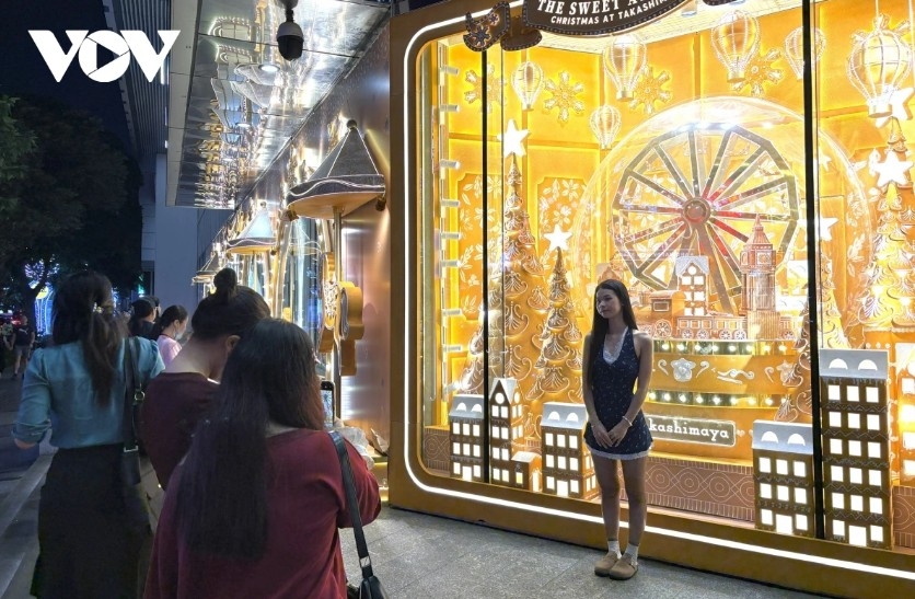 Visitors enjoy taking photos with a Christmas display outside a shopping center