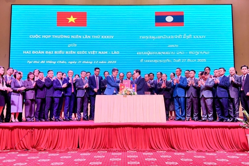 Heads of the Vietnamese and Lao border delegations sign the minutes of the meeting
(Photo: National Boundary Commission )
