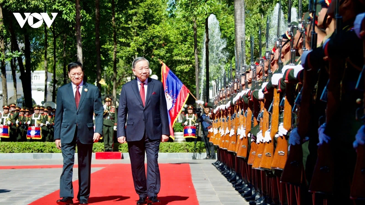 Party General Secretary and President Thongloun Sisoulith of Laos (L) and Party General Secretary To Lam of Vietnam review the guard of honour during the welcoming ceremony for the latter in Vientiane on December 1