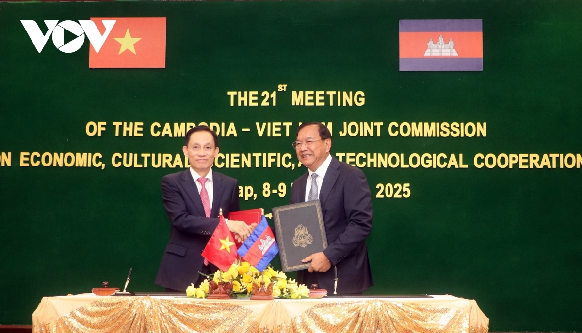 Vietnamese Foreign Minister Le Hoai Trung (L) and Cambodian Deputy Prime Minister and Foreign Minister Prak Sokhonn exchange the minutes of the session