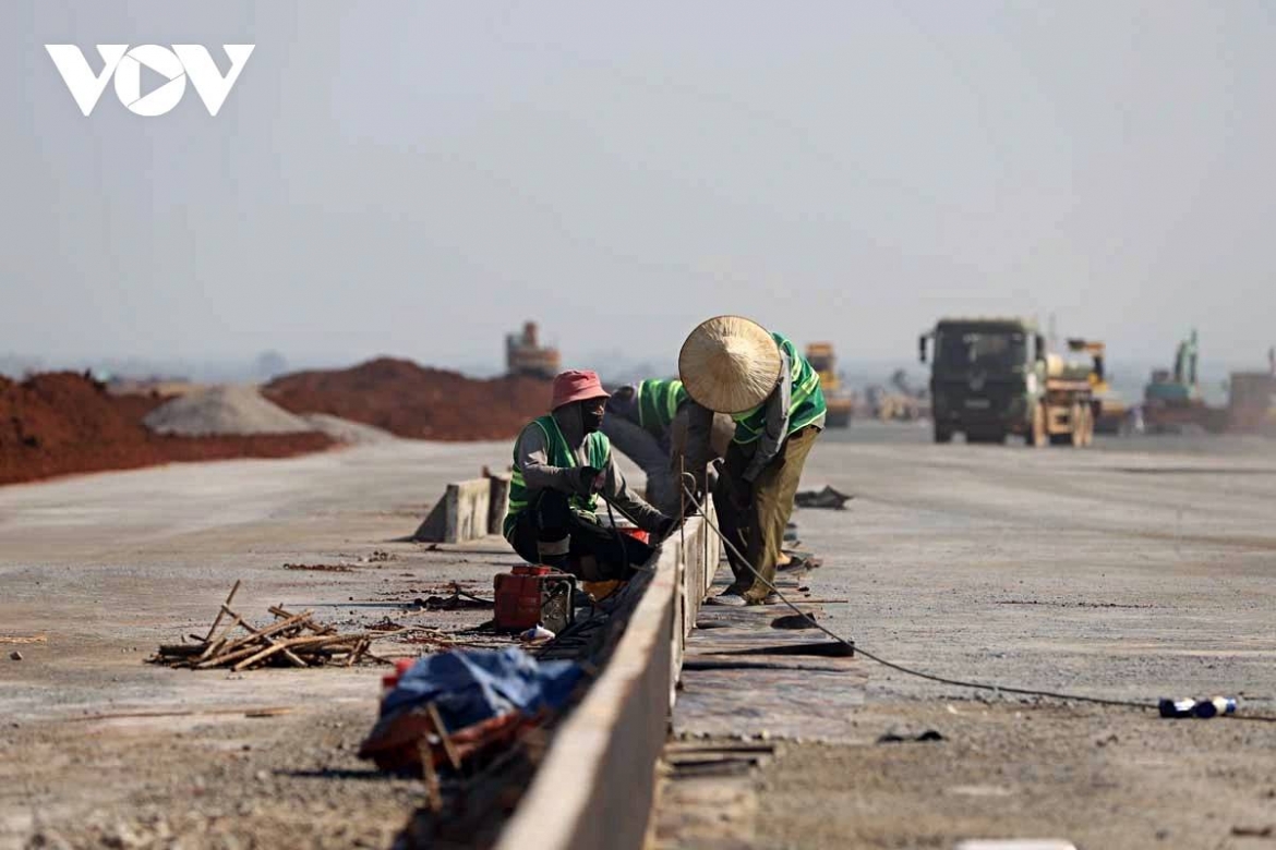Under a blazing sun, workers of Army Corps 12 endure heat radiating from concrete and steel at the Long Thanh airport site.