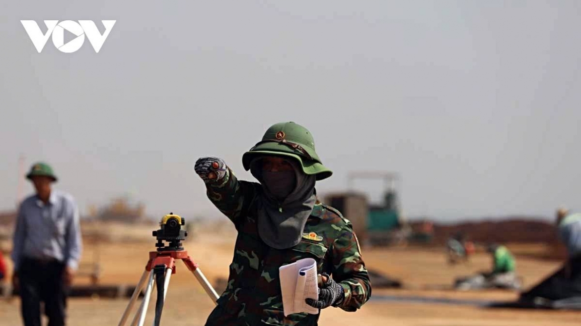 Fully covered to endure the harsh sun, workers of Army Corps 12 direct construction work with precise, decisive gestures at the Long Thanh airport site.
