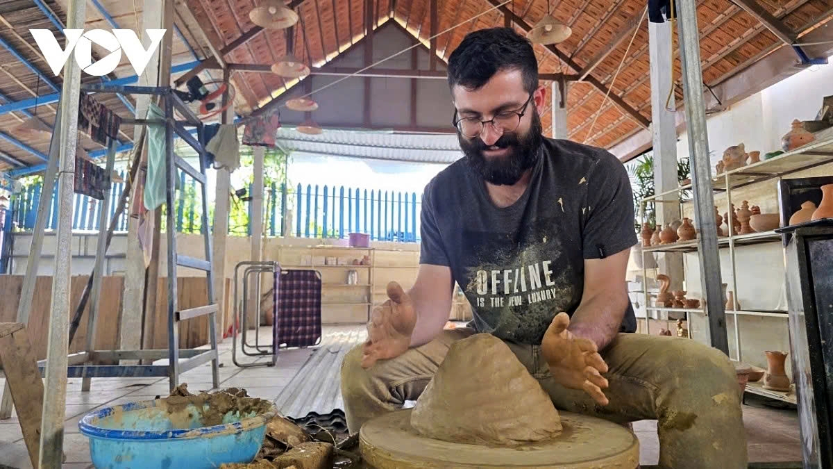 A foreign tourist tries pottery-making at Thanh Ha pottery village