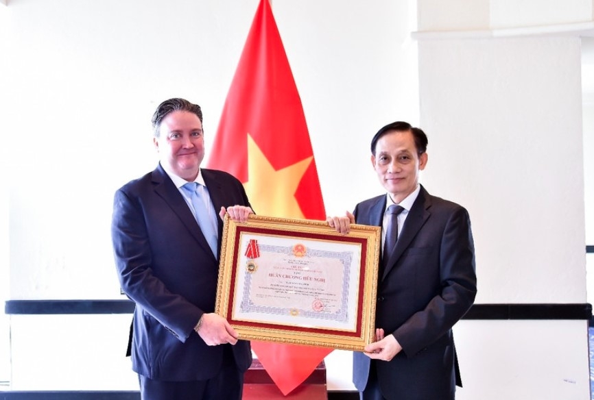 Foreign Minister Le Hoai Trung (right) presents Friendship Order to US Ambassador Marc Knapper (Photo: VNA)